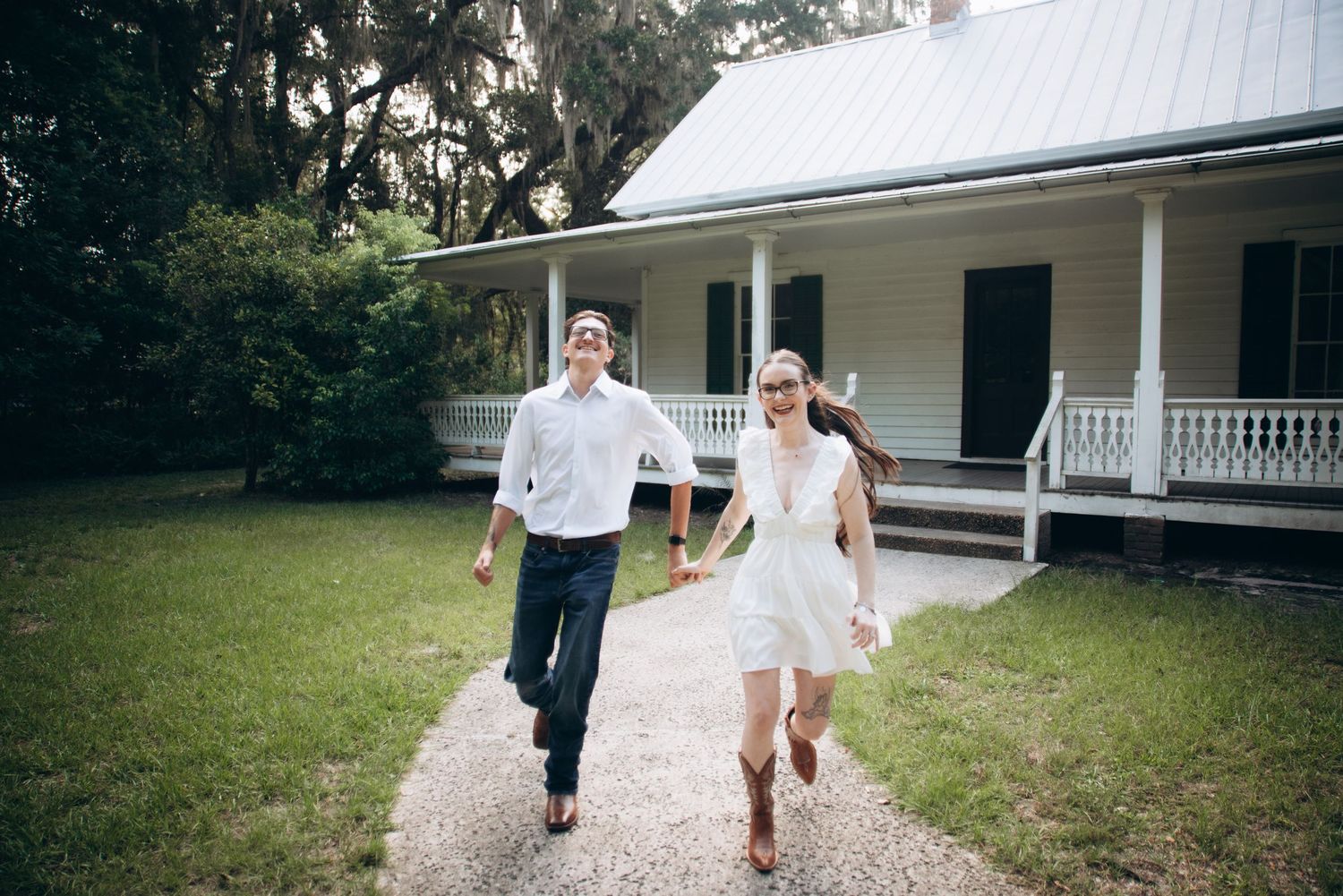 Gravel pathway leading to a classic white Southern plantation-style home.
