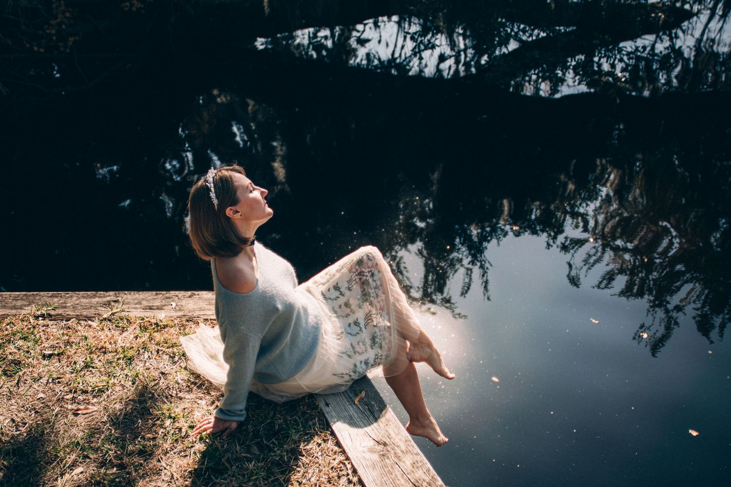 A person in a white dress spins gracefully in a garden setting creating a flowing circular motion effect.