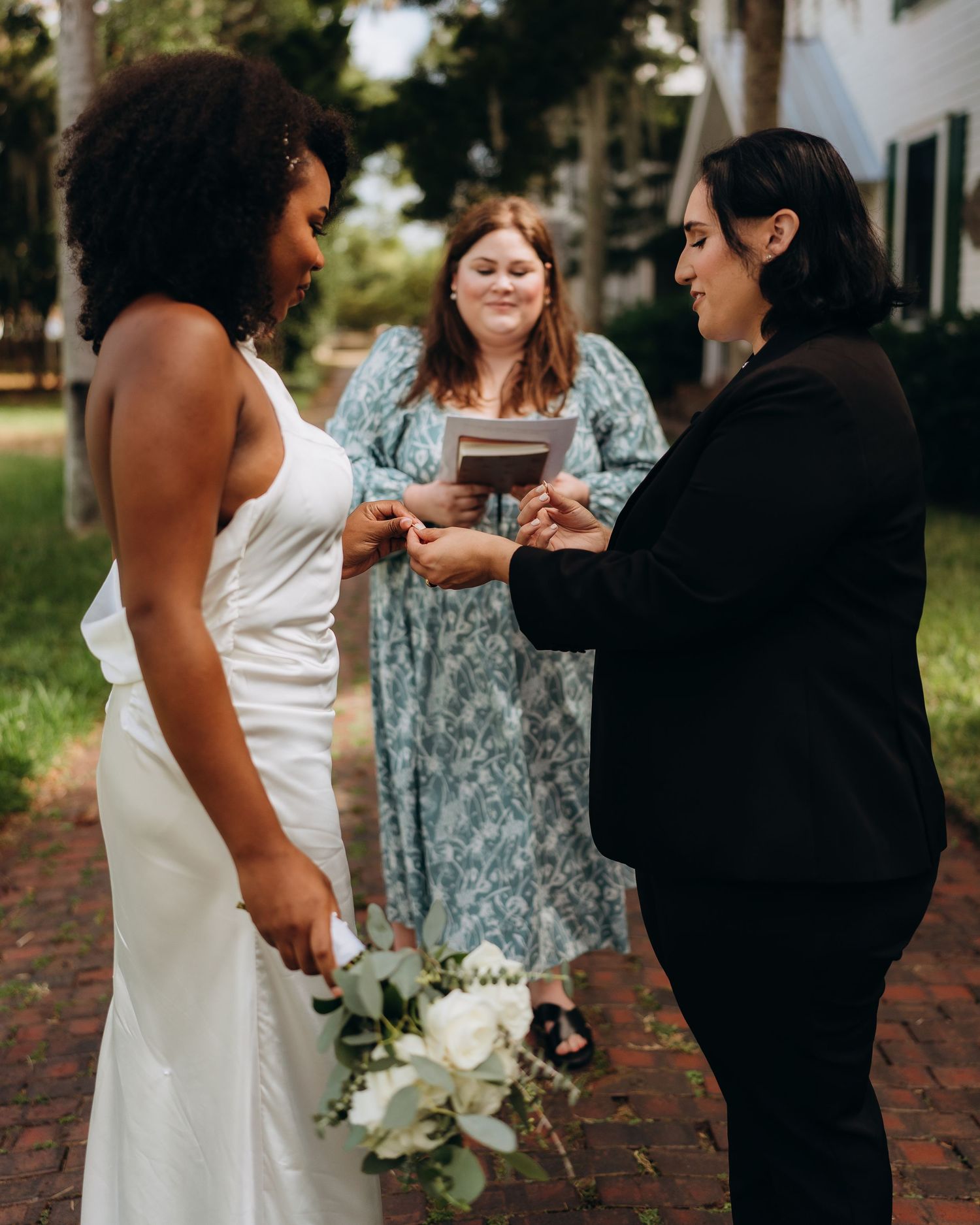 Wedding party gathered on a brick path during an outdoor celebration.