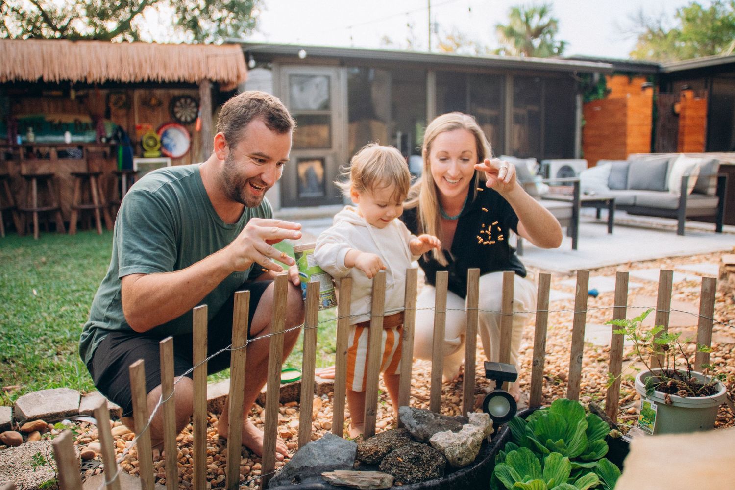 People gather around a wooden fence in a casual outdoor setting.