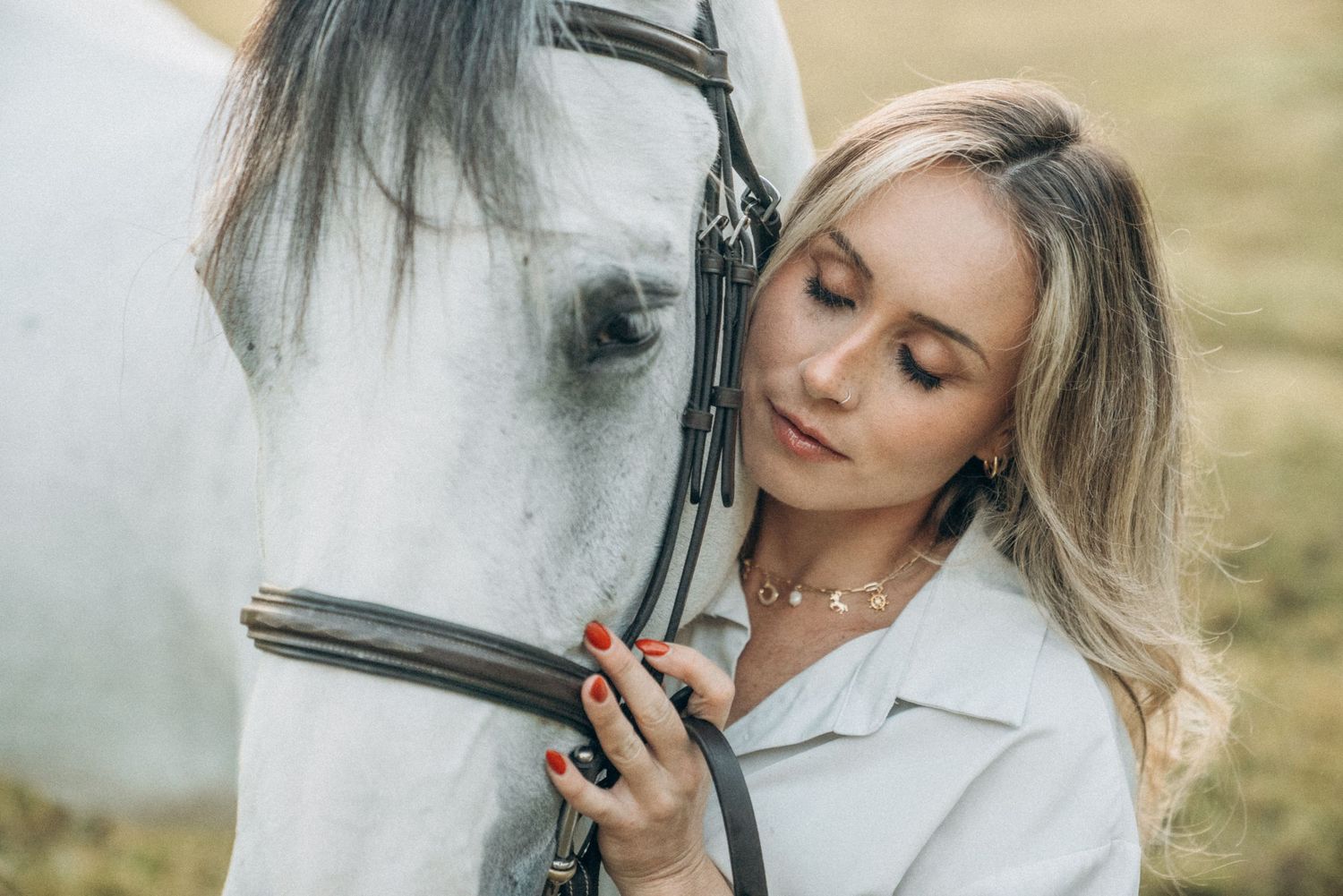 Tender close-up shots of person bonding with white horse against natural backdrop.