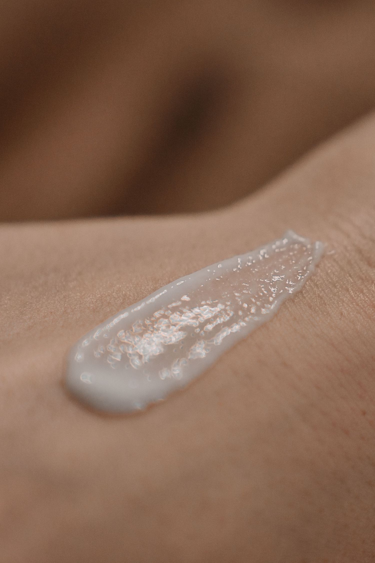 Close-up of a white moisturizing cream smear applied on smooth skin.