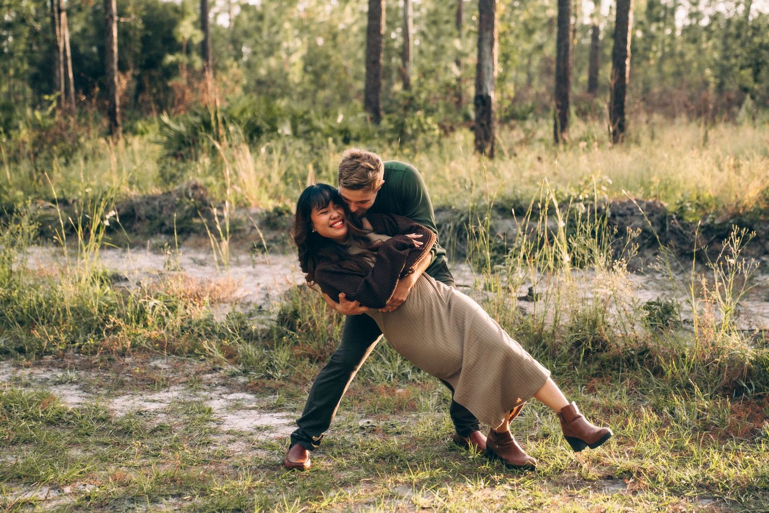 Playful outdoor photo session in natural setting with warm sunset lighting.