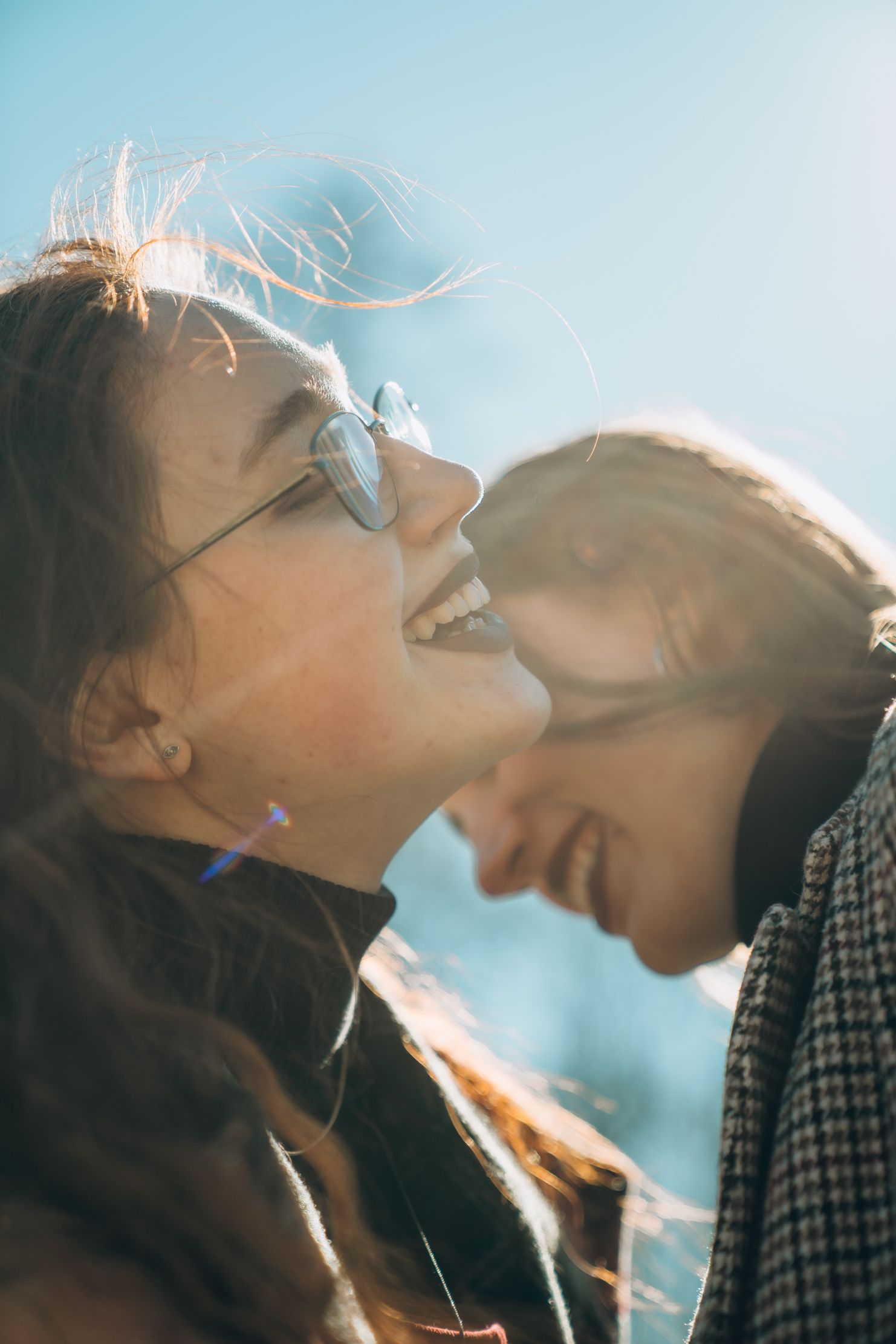 Intimate close-up of couple sharing a tender moment in sunlight.