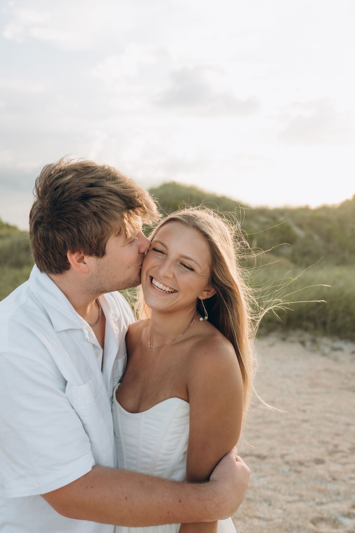 A joyful moment shared between a couple on a sunny beach.