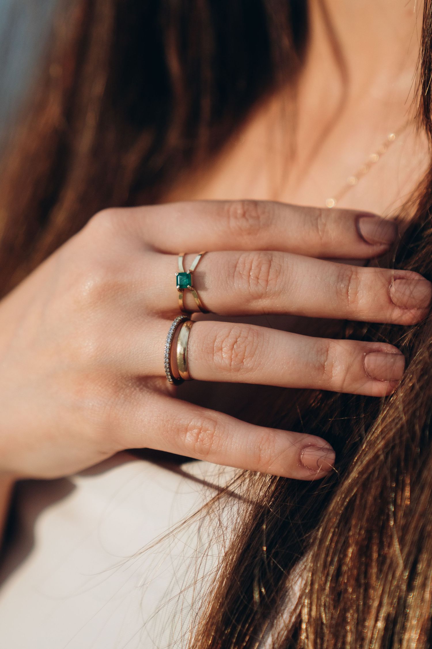 Close-up shots of hands wearing engagement rings with hair in the background.