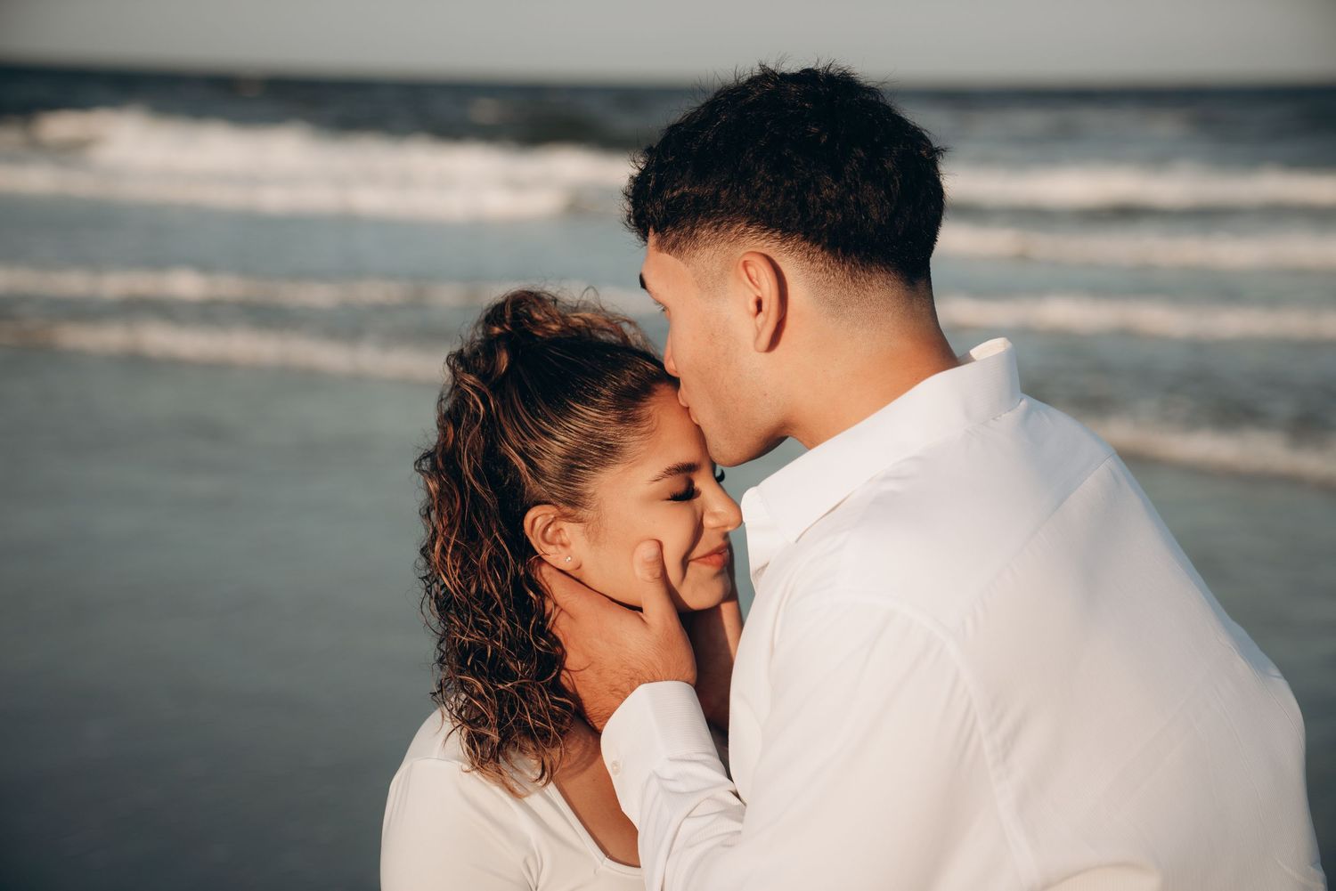 Intimate beachside maternity photos with waves and ocean in the background.