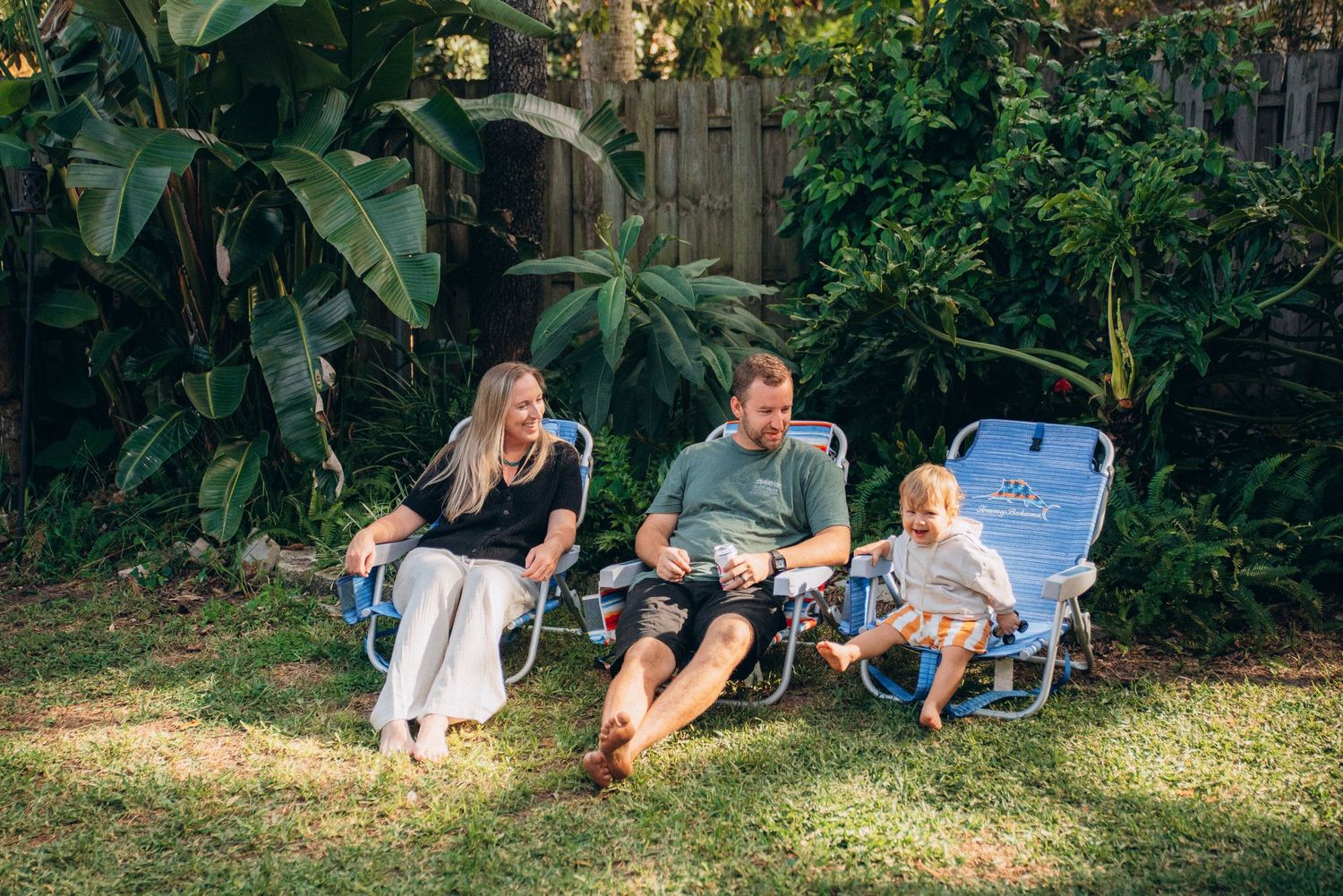 A group of people lie on grass enjoying a relaxed outdoor gathering.