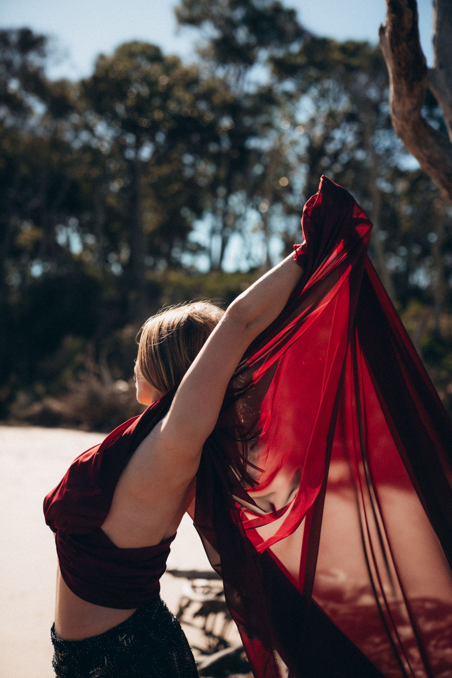 A sequence of images showing a red fabric flowing against a backdrop of trees in natural sunlight.