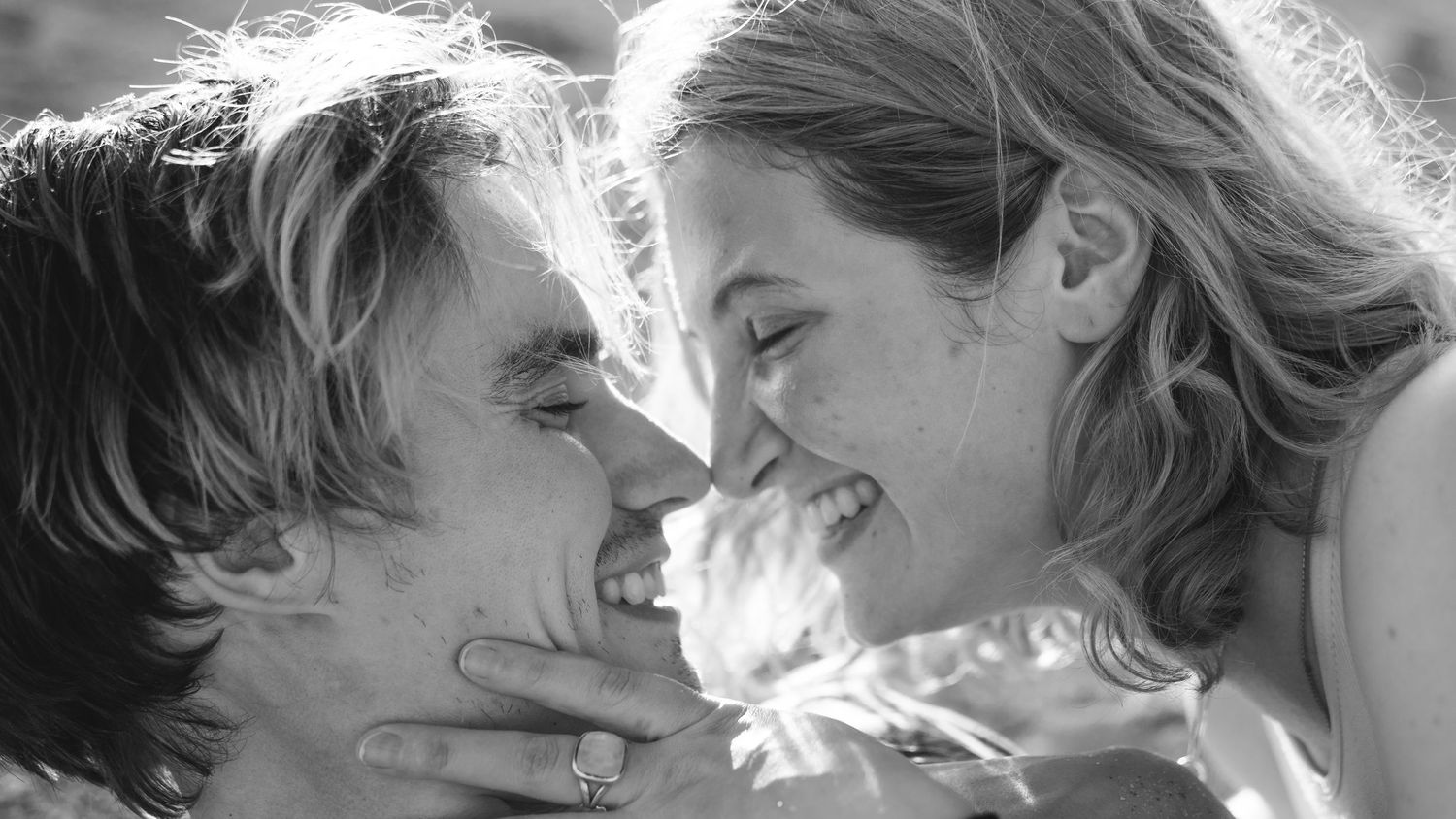 Black and white close-up portraits of a couple sharing tender moments in natural light.