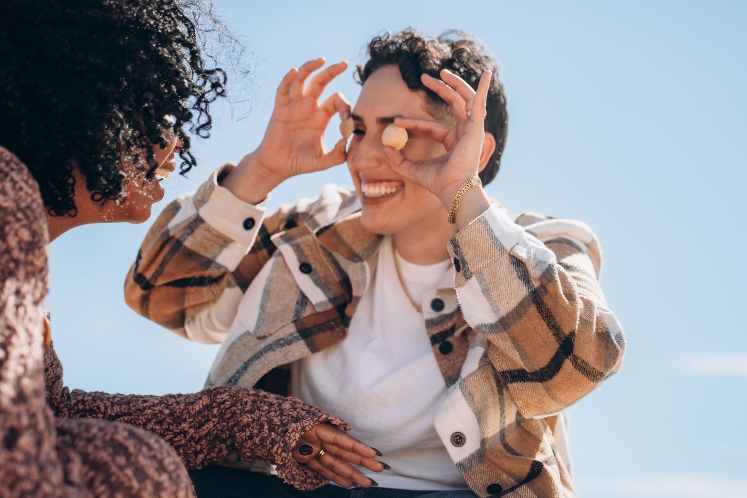A playful moment captured between two people on a bright sunny day.