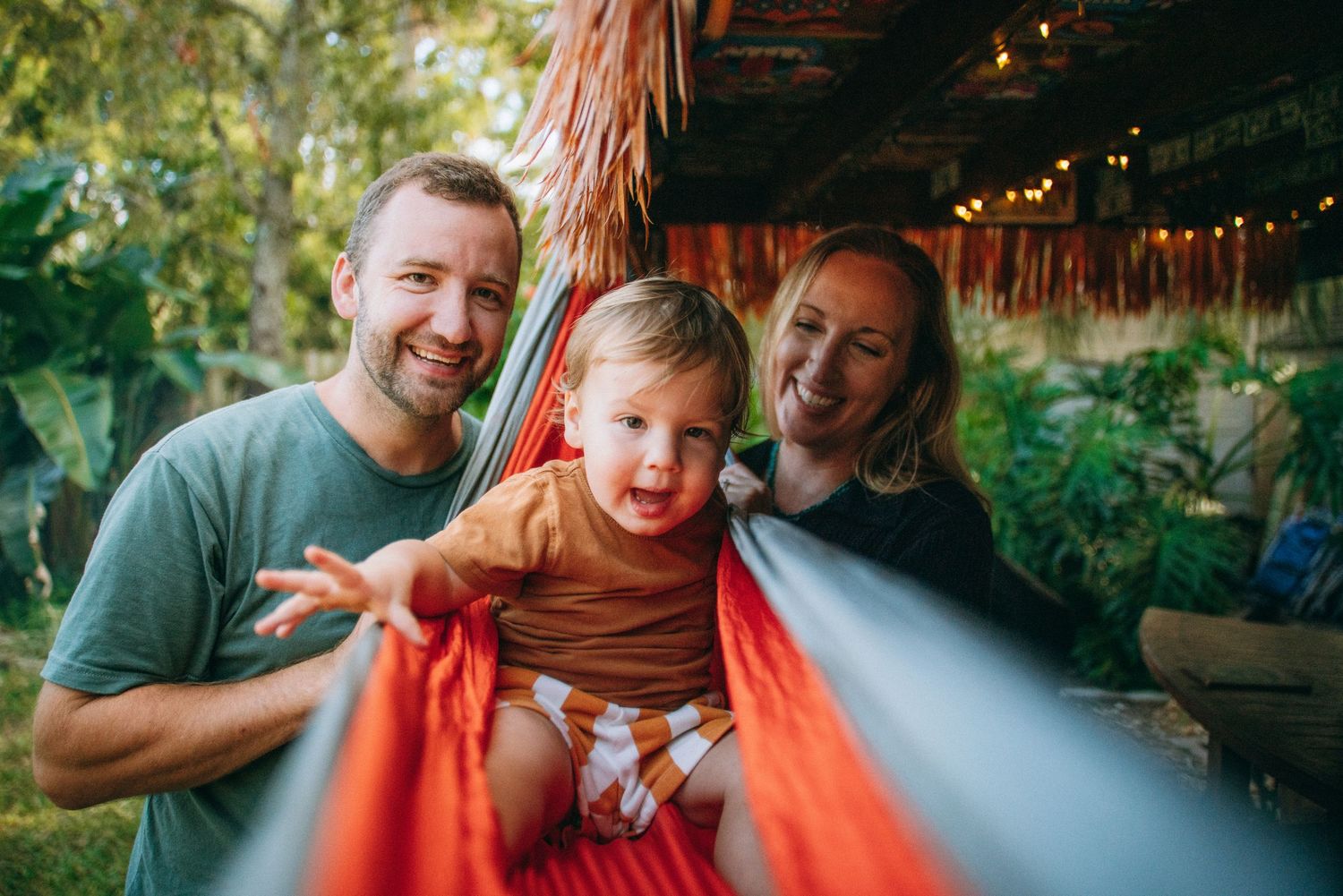Family shares playful moments under outdoor patio lights.