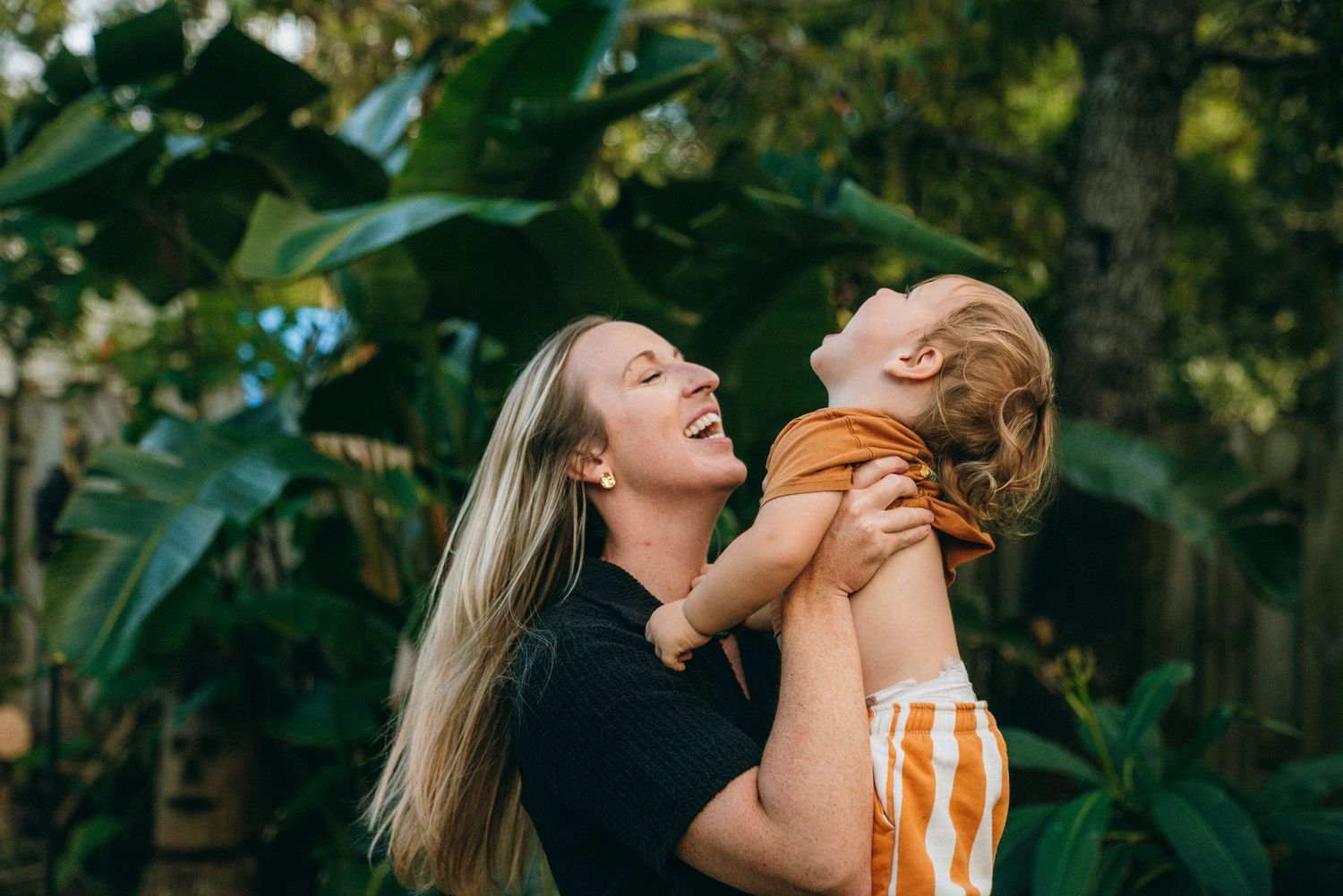Candid family photoshoot showing playful interactions outdoors.