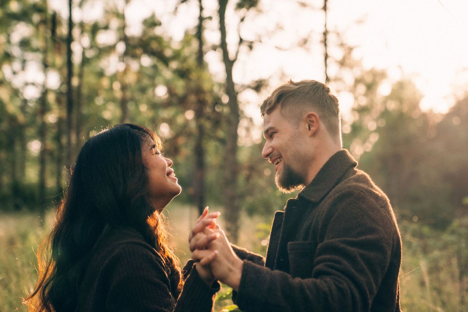 Romantic golden hour photoshoot in autumn setting with natural sunlight filtering through trees.