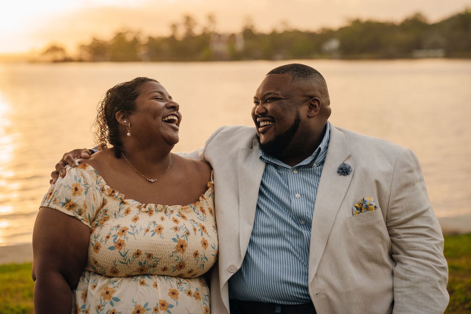 A romantic sunset photoshoot by a lake with a couple in matching outfits sharing joyful moments together.
