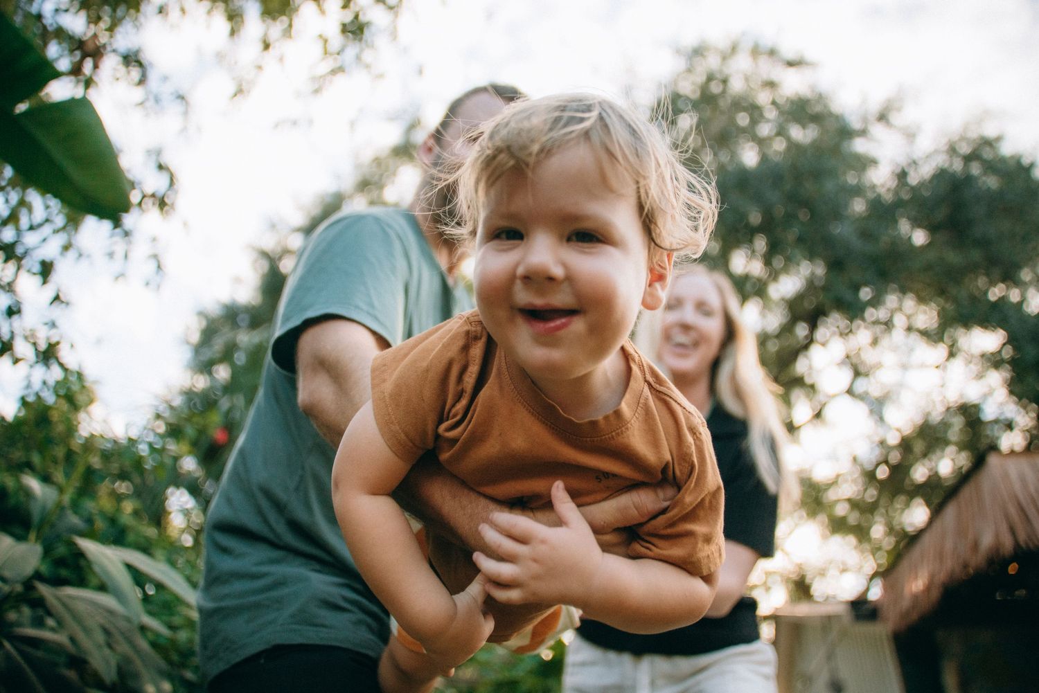 Loving family moment captured in a backyard garden setting.