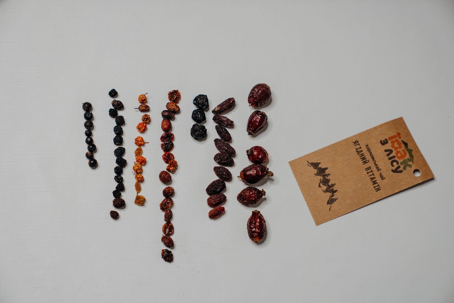 Assorted amber beads and earrings in various colors including black, orange, and red-brown displayed on white background.