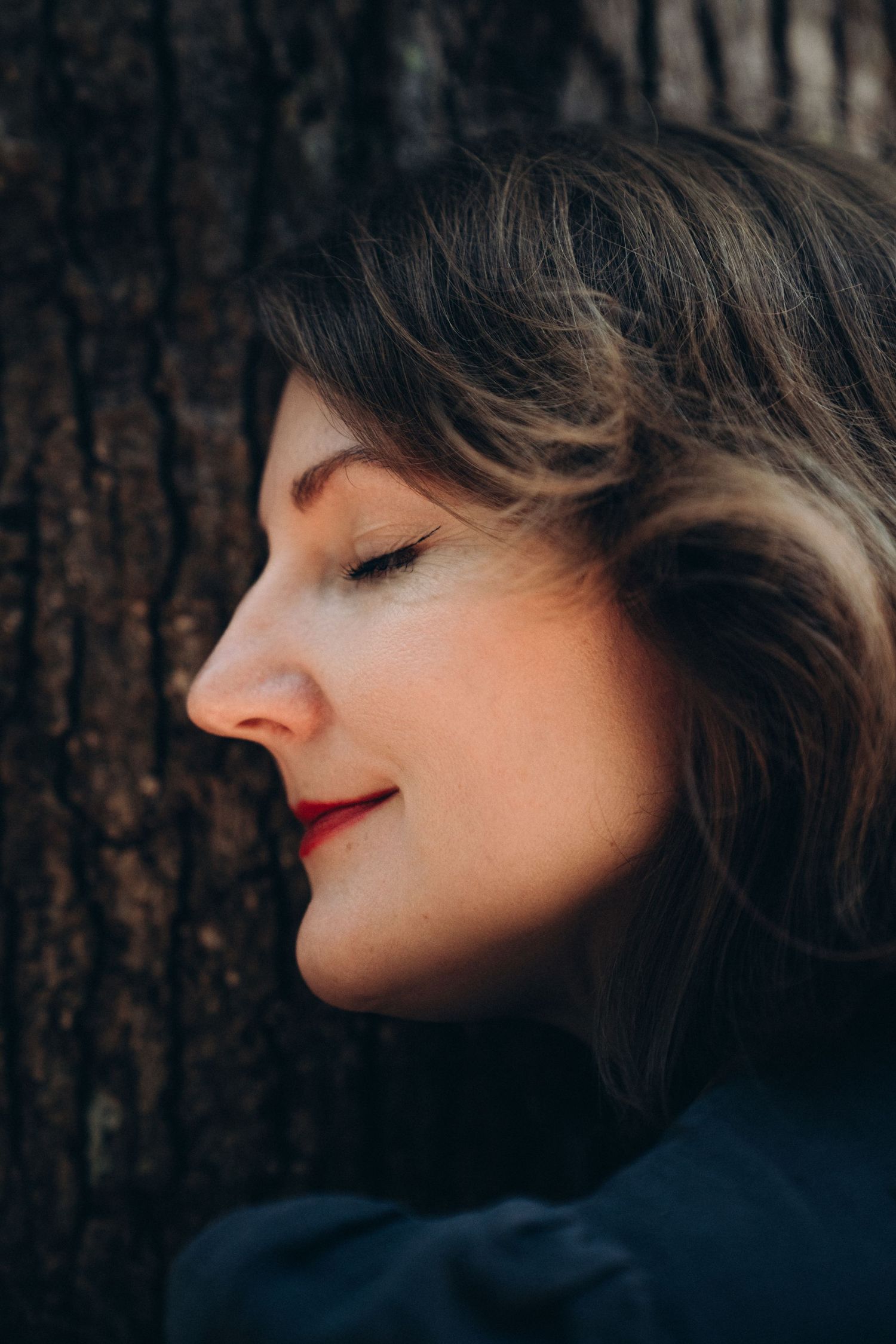 Profile silhouettes against dark tree trunks showing dramatic contrasts and red lipstick details.