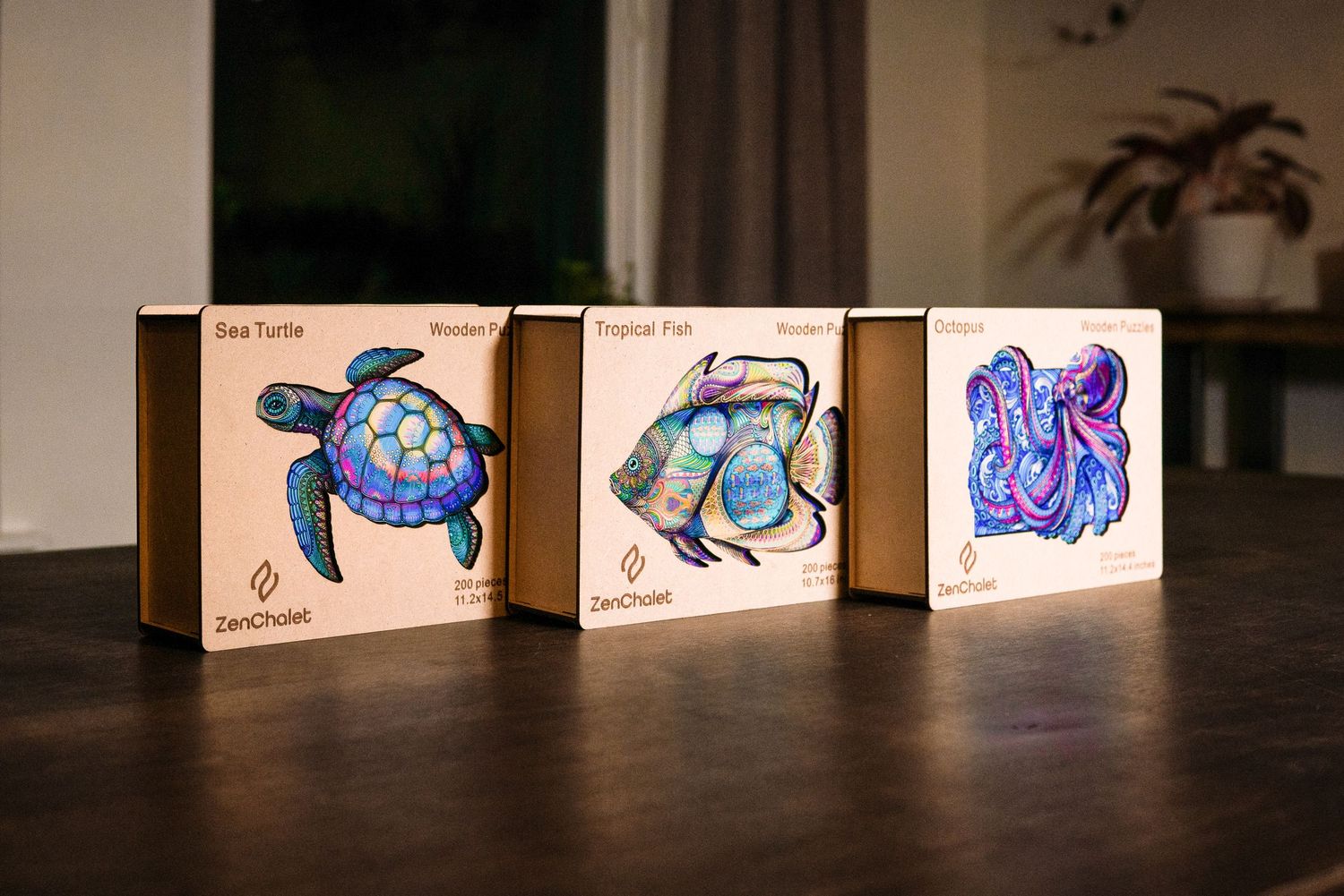 Three ZenChosen wooden puzzle boxes featuring Sea Turtle, Tropical Fish, and Octopus designs displayed on a wooden table.