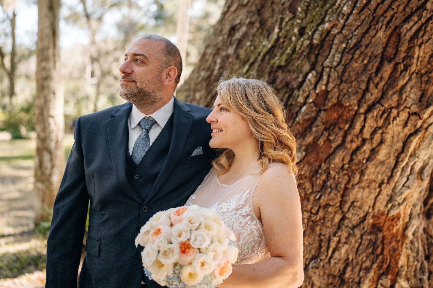 Tender wedding portraits taken against the backdrop of a massive tree trunk.