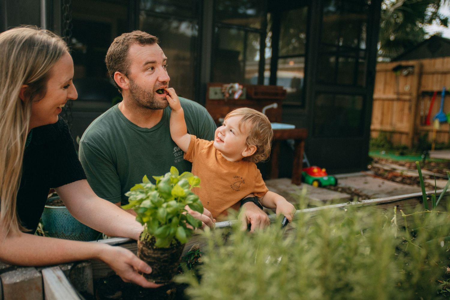 Candid moments of family interaction captured in garden setting.