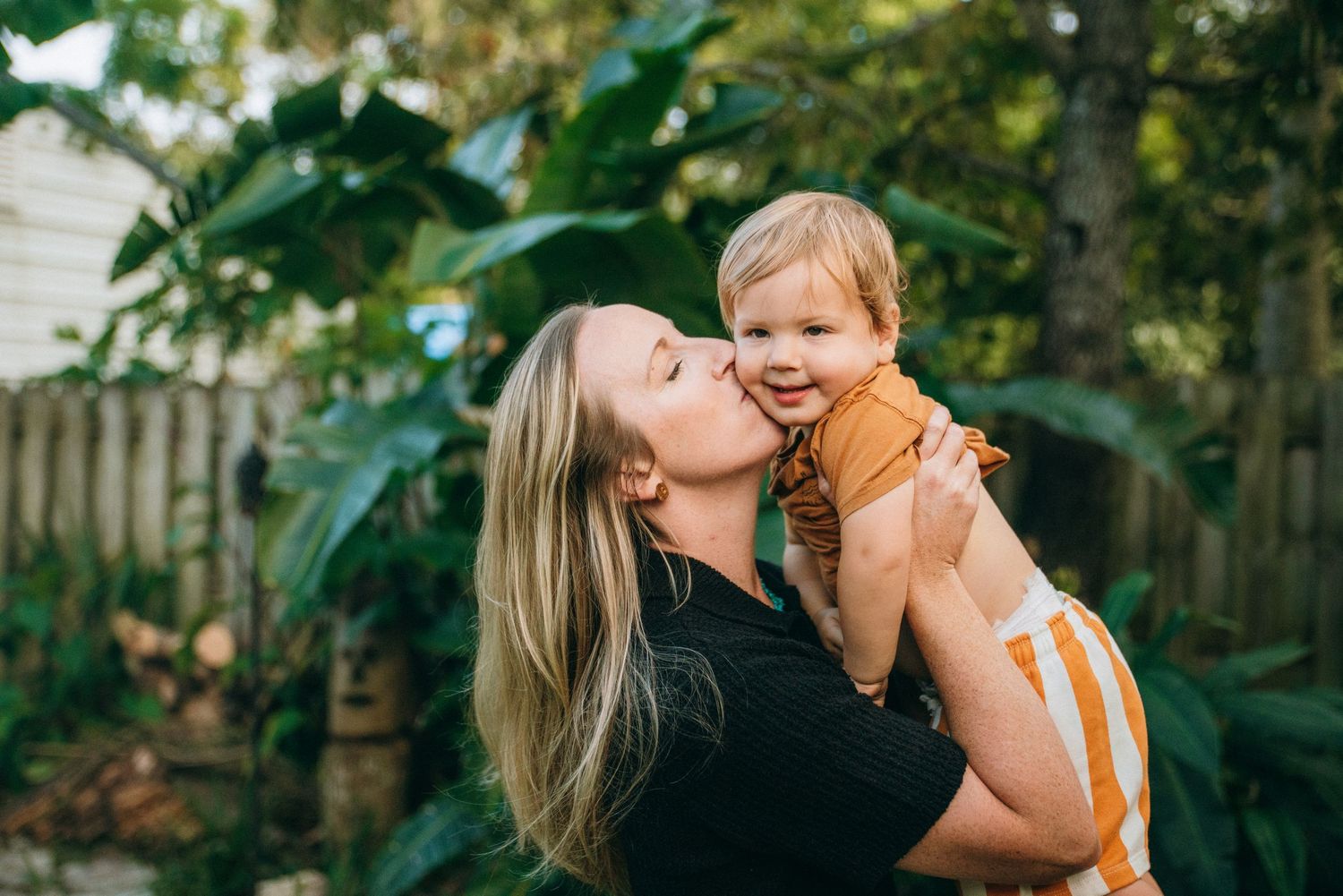 Joyful family moment captured in a lush garden setting during golden hour.