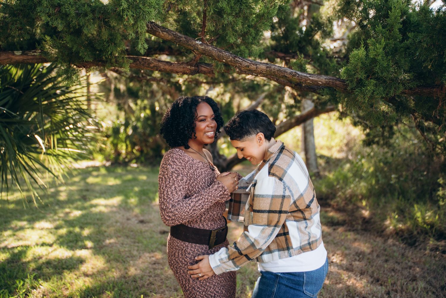 Romantic couple shares tender moments together in a lush garden setting with dappled sunlight.