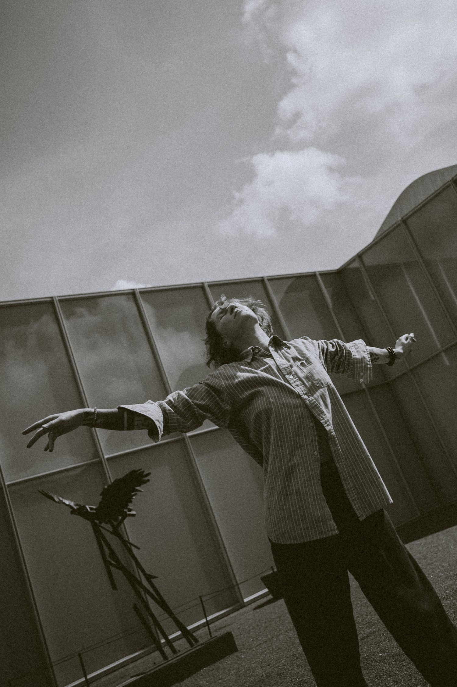 Dramatic black and white sequence showing figure leaning against wall in artistic poses.