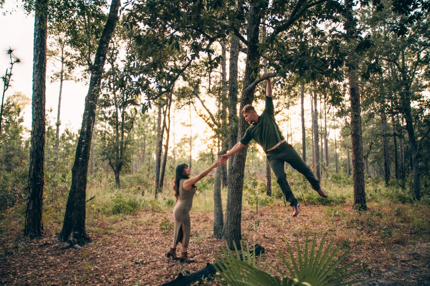 Dreamy forest engagement session with backlit trees creating magical atmosphere in natural setting.