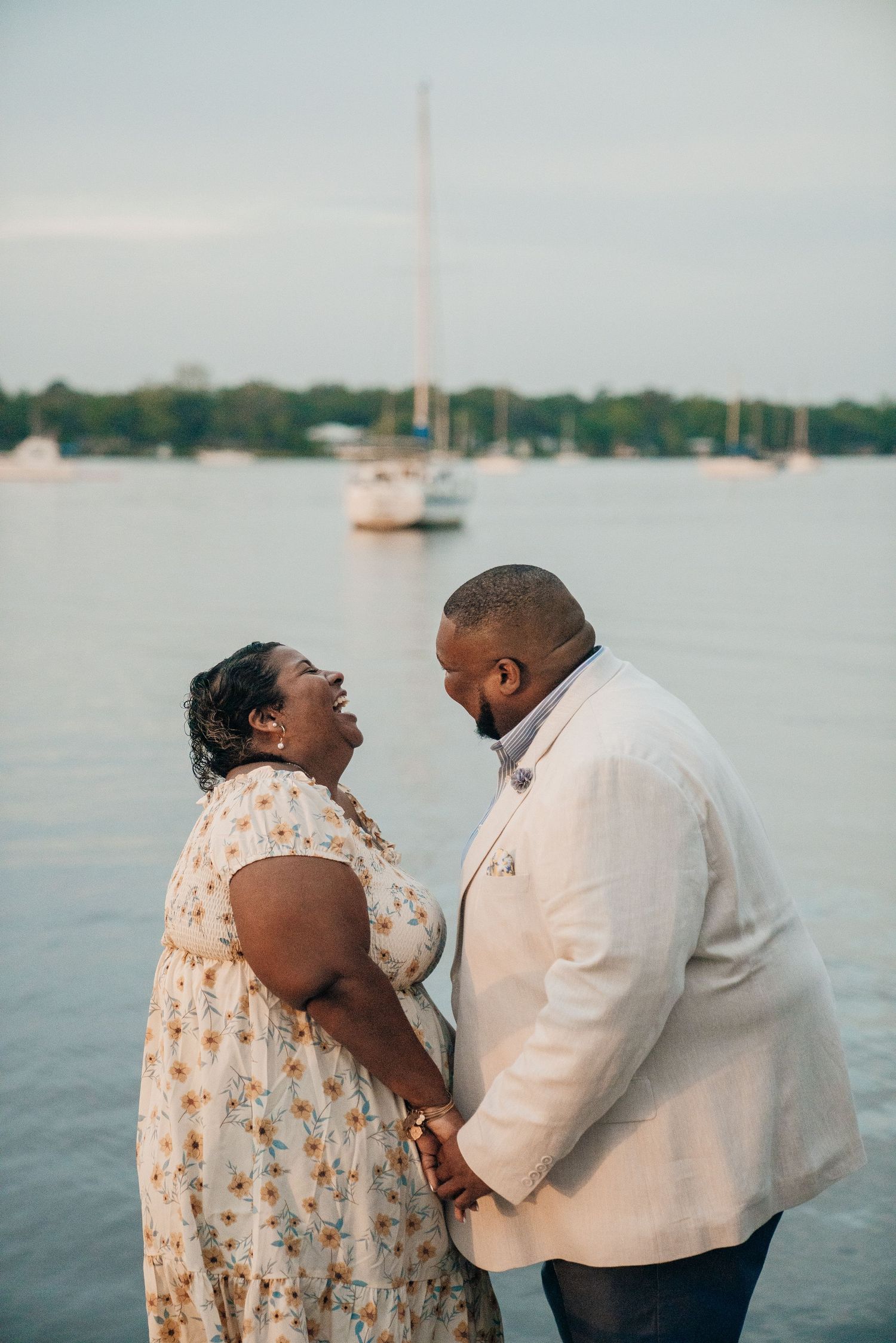 Couple sharing intimate moments on a dock during golden hour.