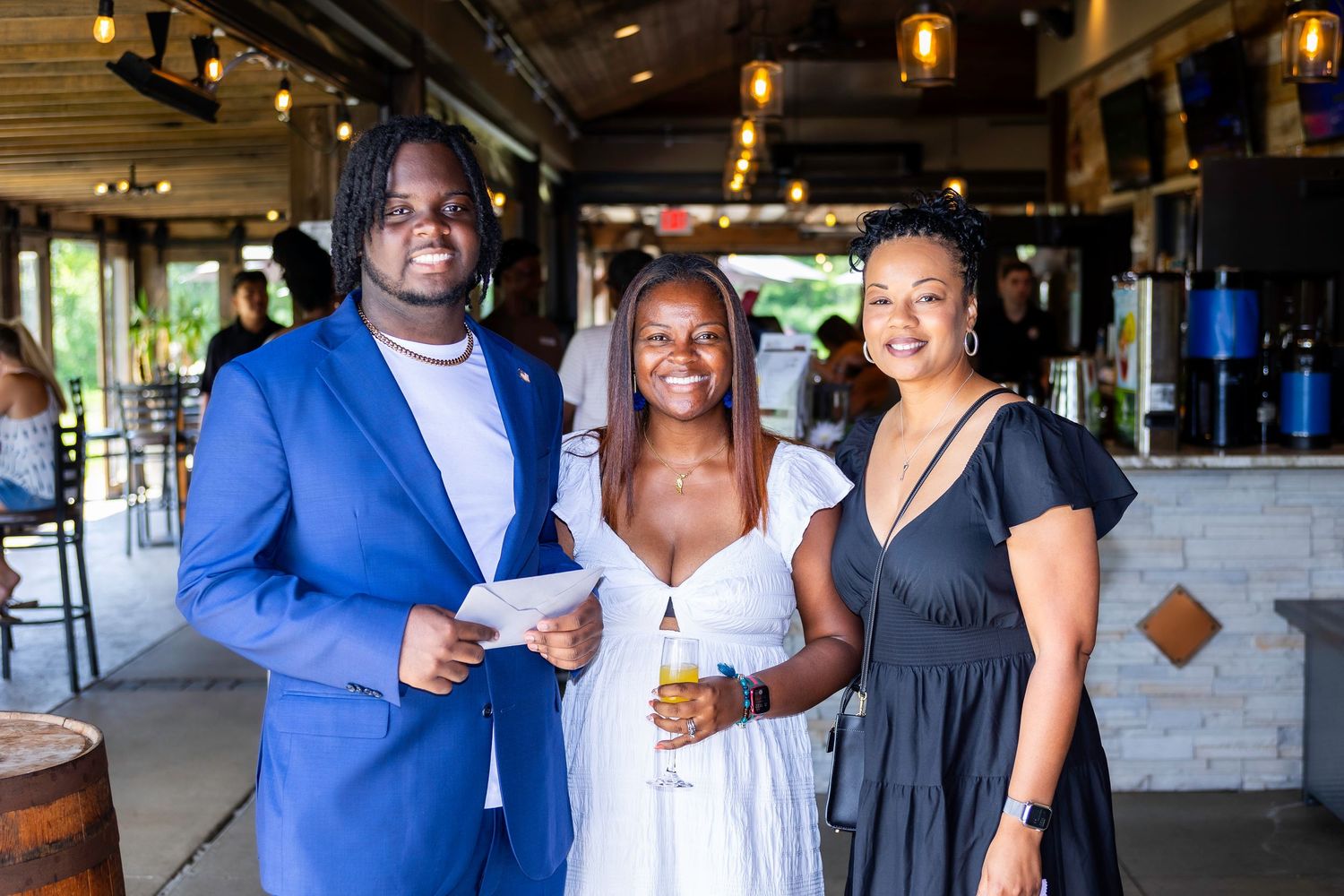 Guests enjoying drinks and conversation at a modern venue with pendant lighting.