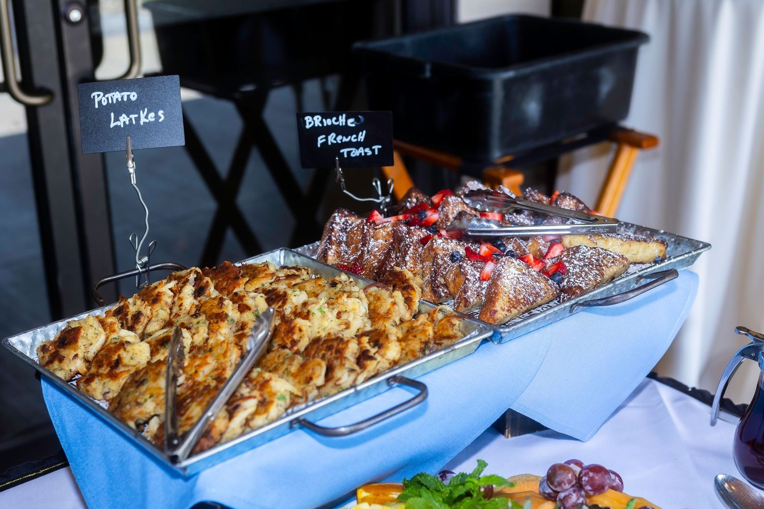Catering buffet setup with various dishes displayed in silver serving trays.