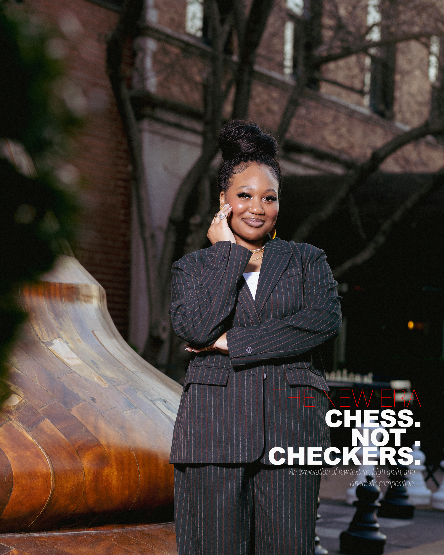 Woman in pinstripe suit smiling outdoors near sculpture, with text Chess Not Checkers overlay.