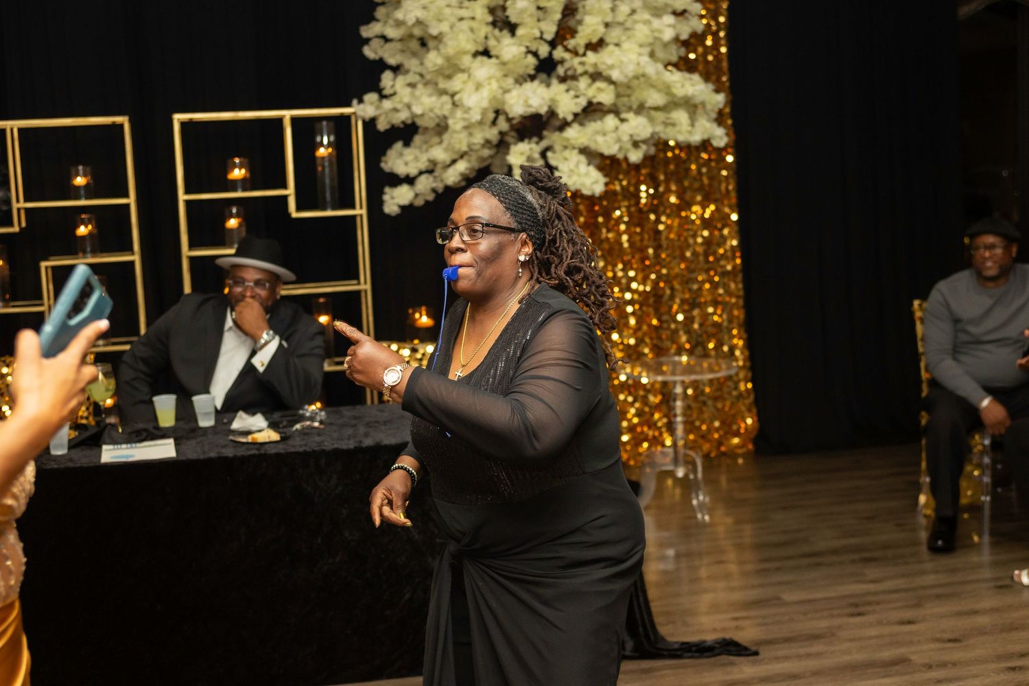 Guests dancing and enjoying themselves at an elegant indoor celebration with gold decor elements.