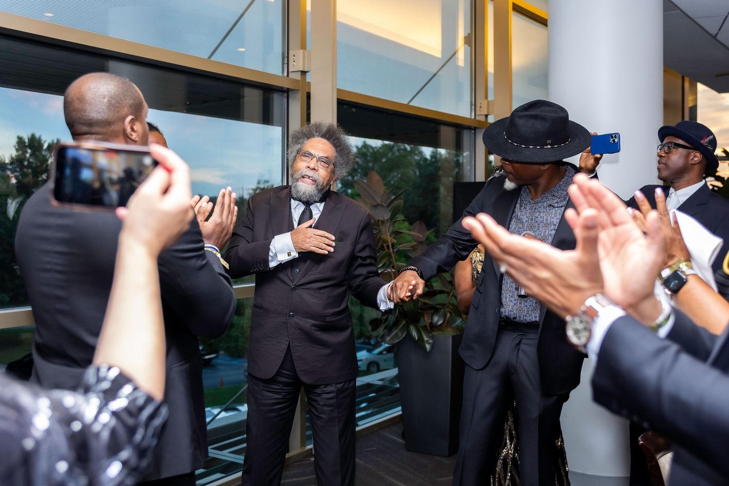 Guests mingling and taking photos at an elegant indoor celebration.