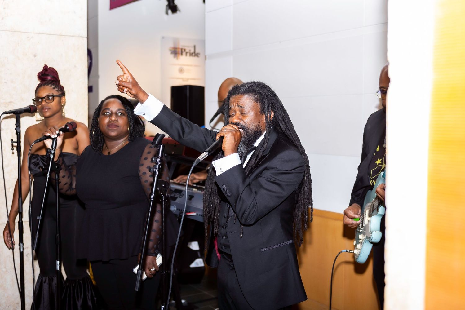 Performers singing passionately on stage during an entertainment segment at an event.