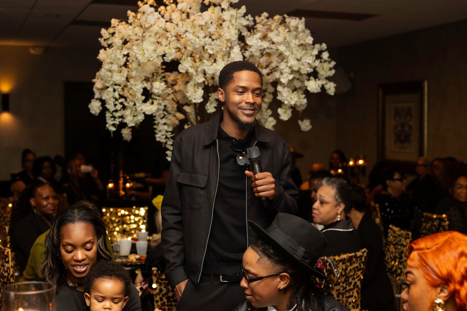 Event space decorated with luxurious white floral arrangements and golden accent lighting.
