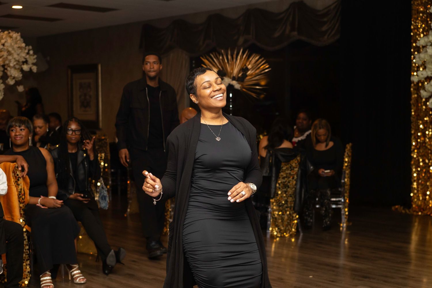 Guest dancing at an elegant party with gold decorations and string lights.