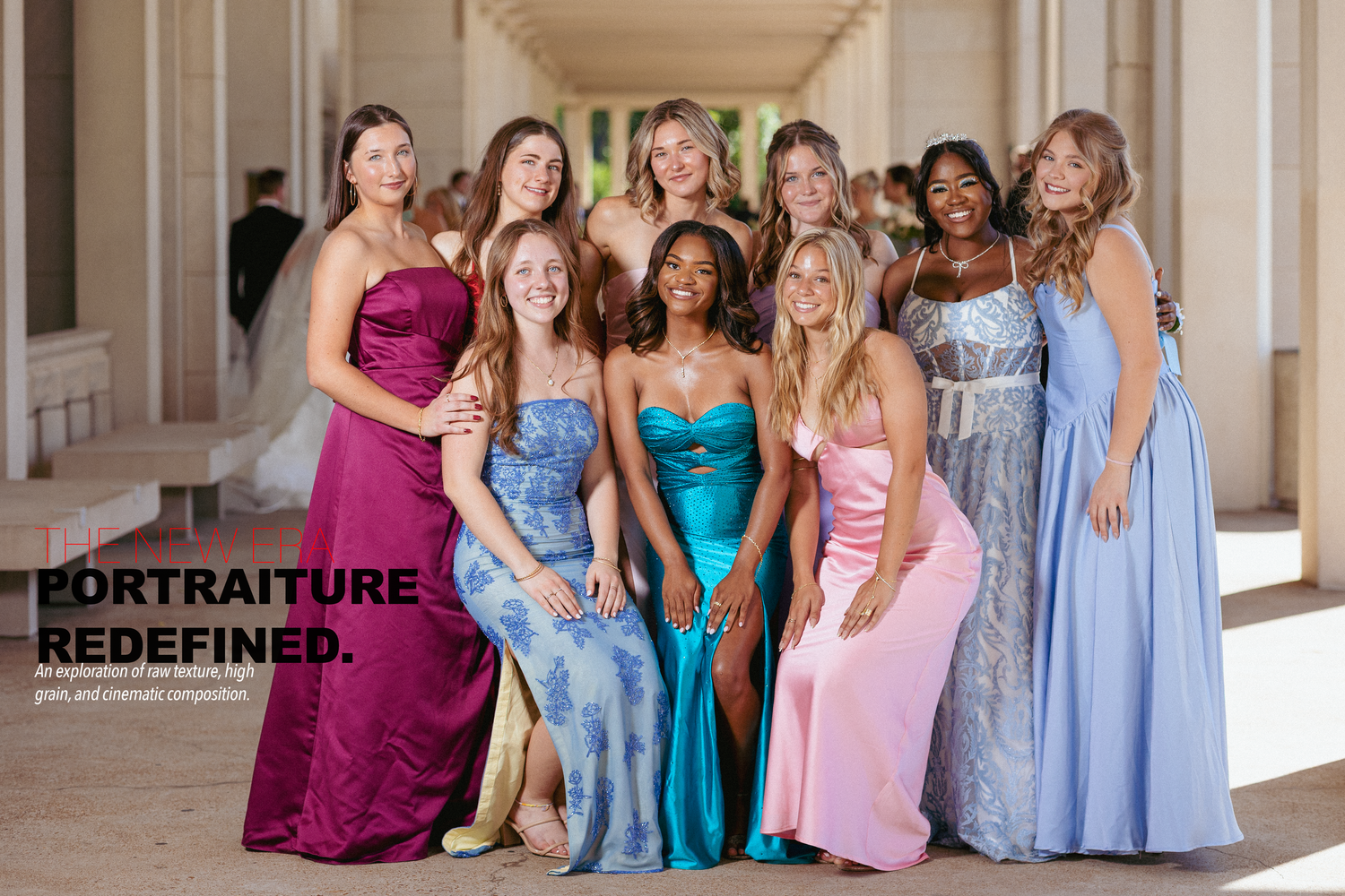 Group of nine women in colorful formal gowns posing together in an elegant columned hallway at prom.