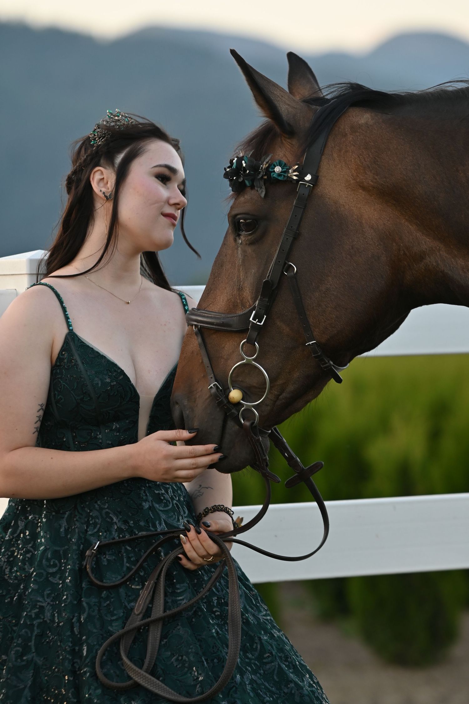Female in green grad dress holding horse's reins