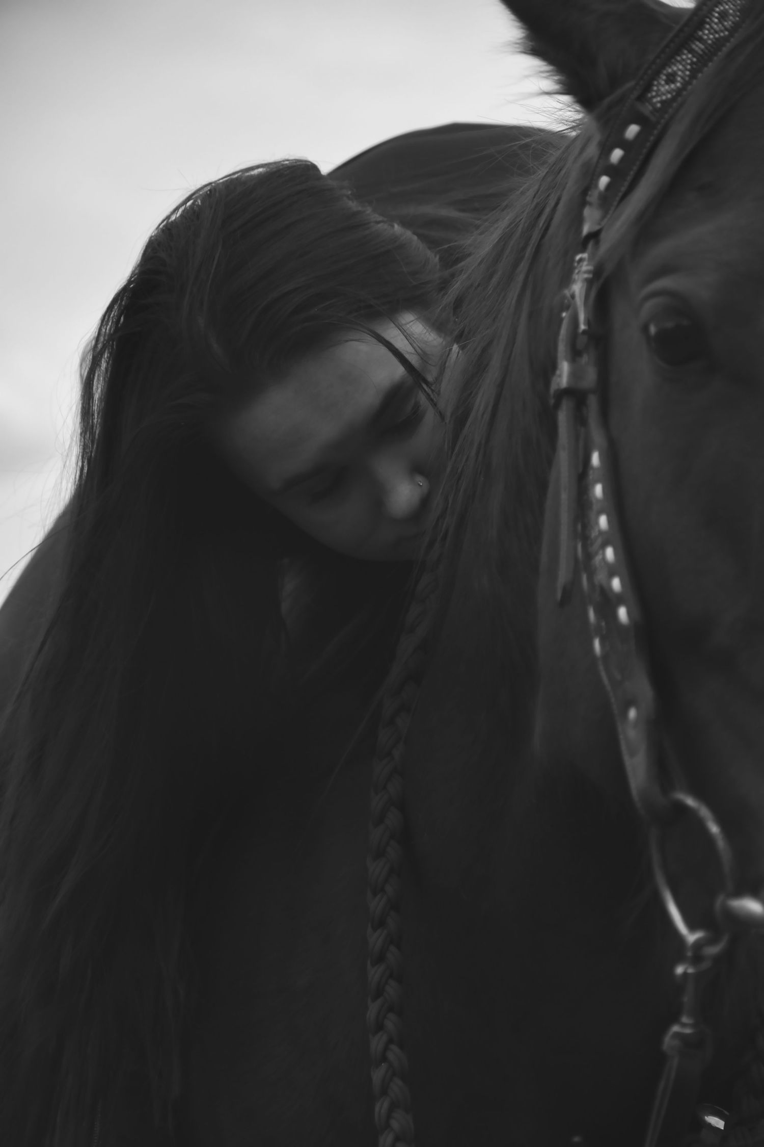 black and white, female hugging horse from up top