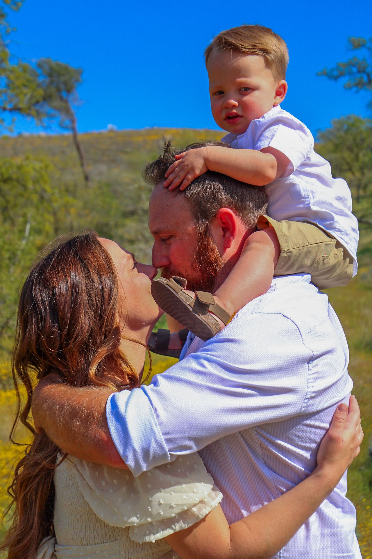 mom and dad hugging with baby boy on dads shoulders
Kern County Photography
Tori Marie Photos
Family Photographer