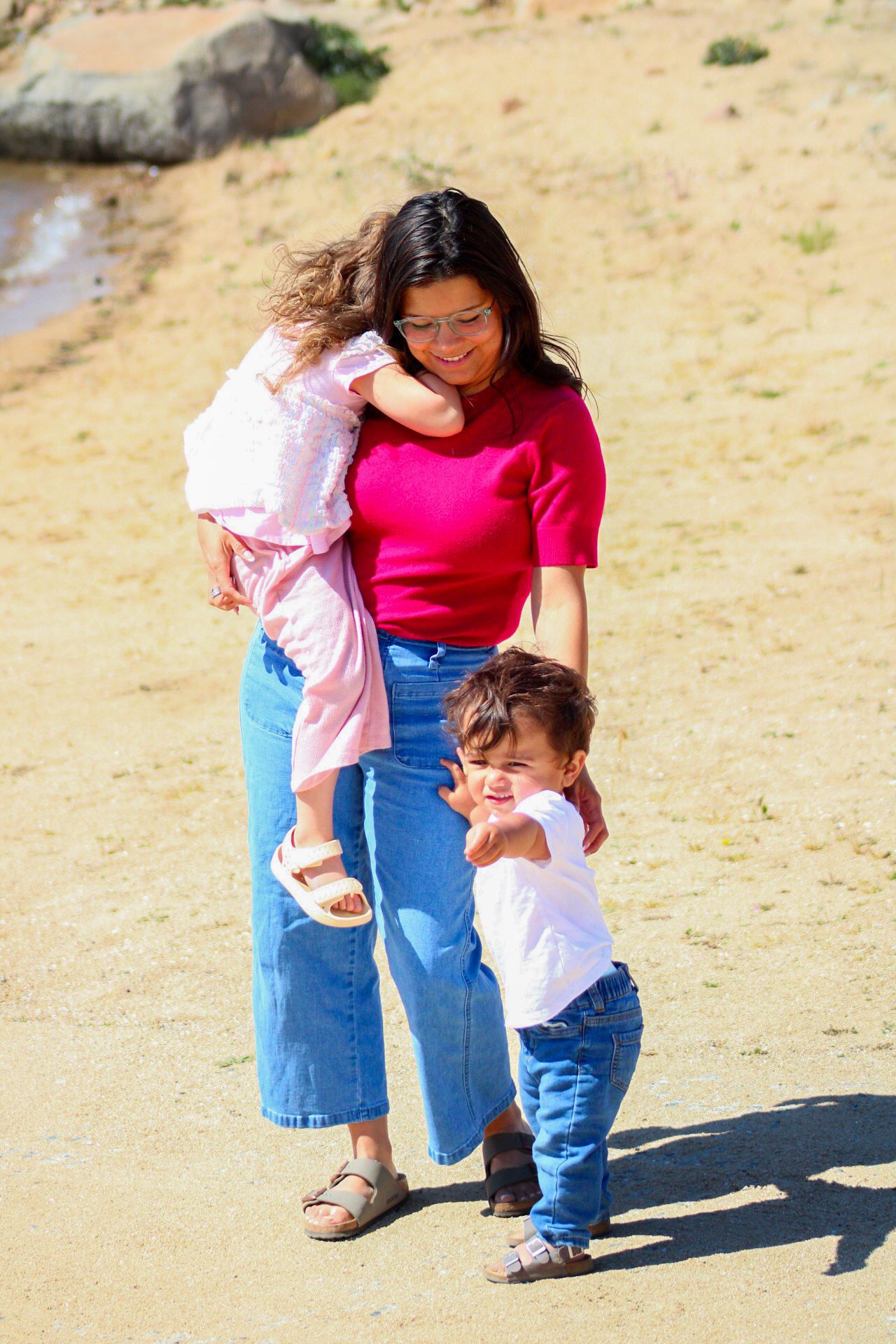 mom holding daughter with son holding her leg pointing forward
Kern county photography 
Family photography 
candid family photoshoot