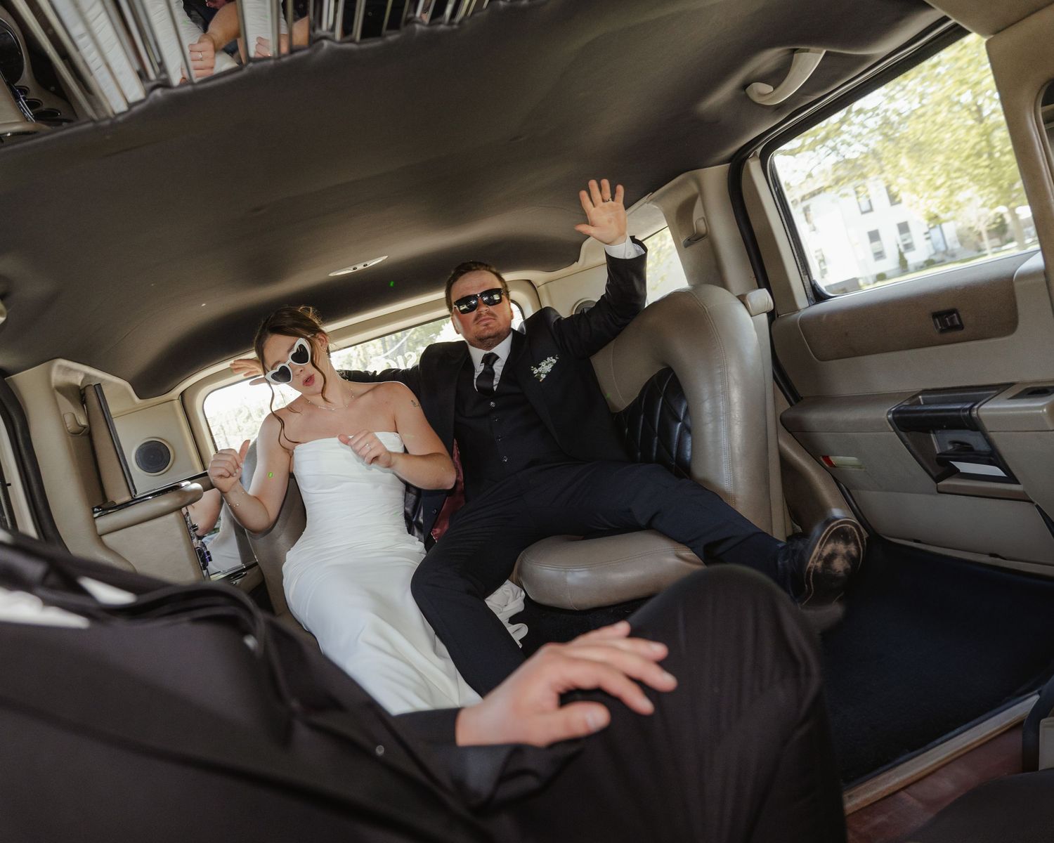 Wedding couple shares intimate moments inside a limousine during their special day.