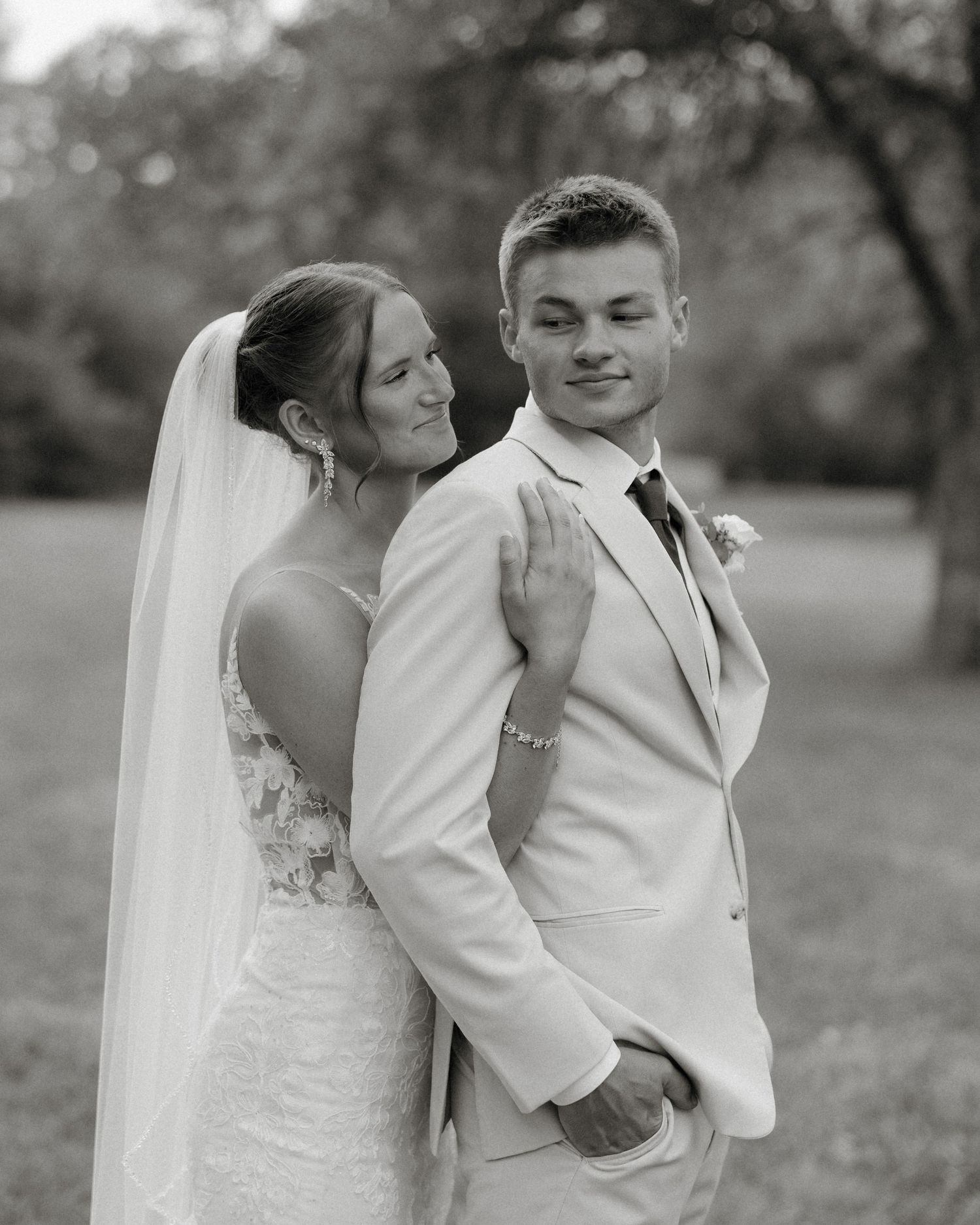 Black and white romantic wedding photo series showing intimate moments between a couple in formal attire outdoors.