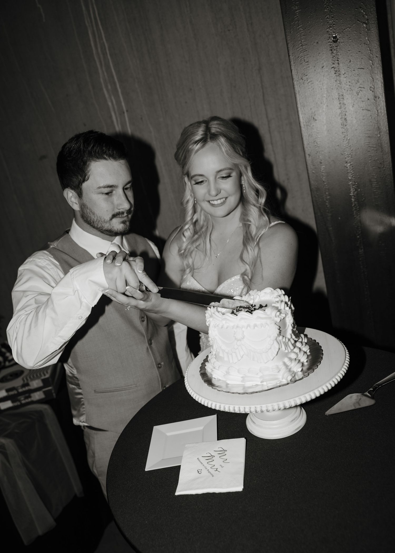 A black and white photo sequence showing a couple cutting and feeding each other wedding cake at their reception.