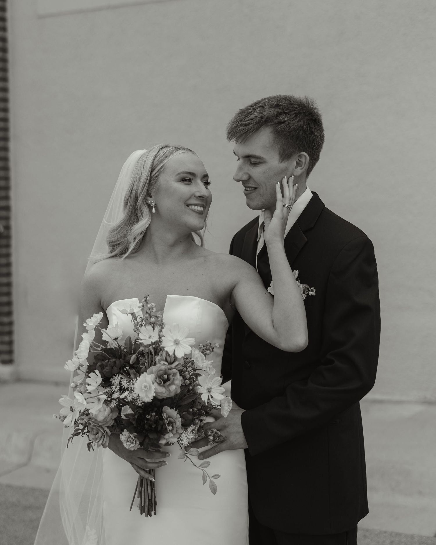 Black and white wedding photo series showing romantic moments between newlyweds with bouquet and formal attire.