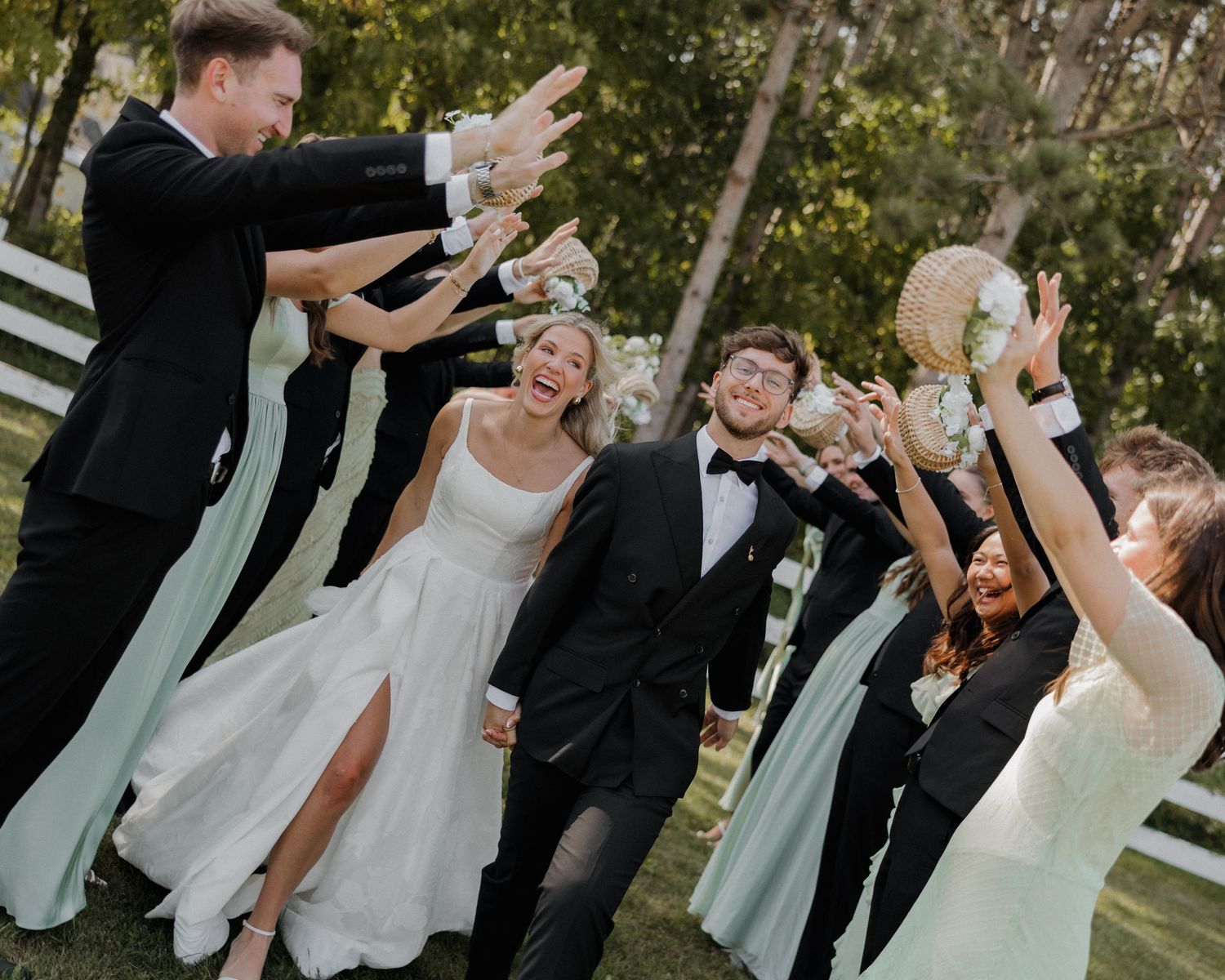 Wedding party celebrates joyfully together outdoors in a candid sequence of dance moves and laughter.