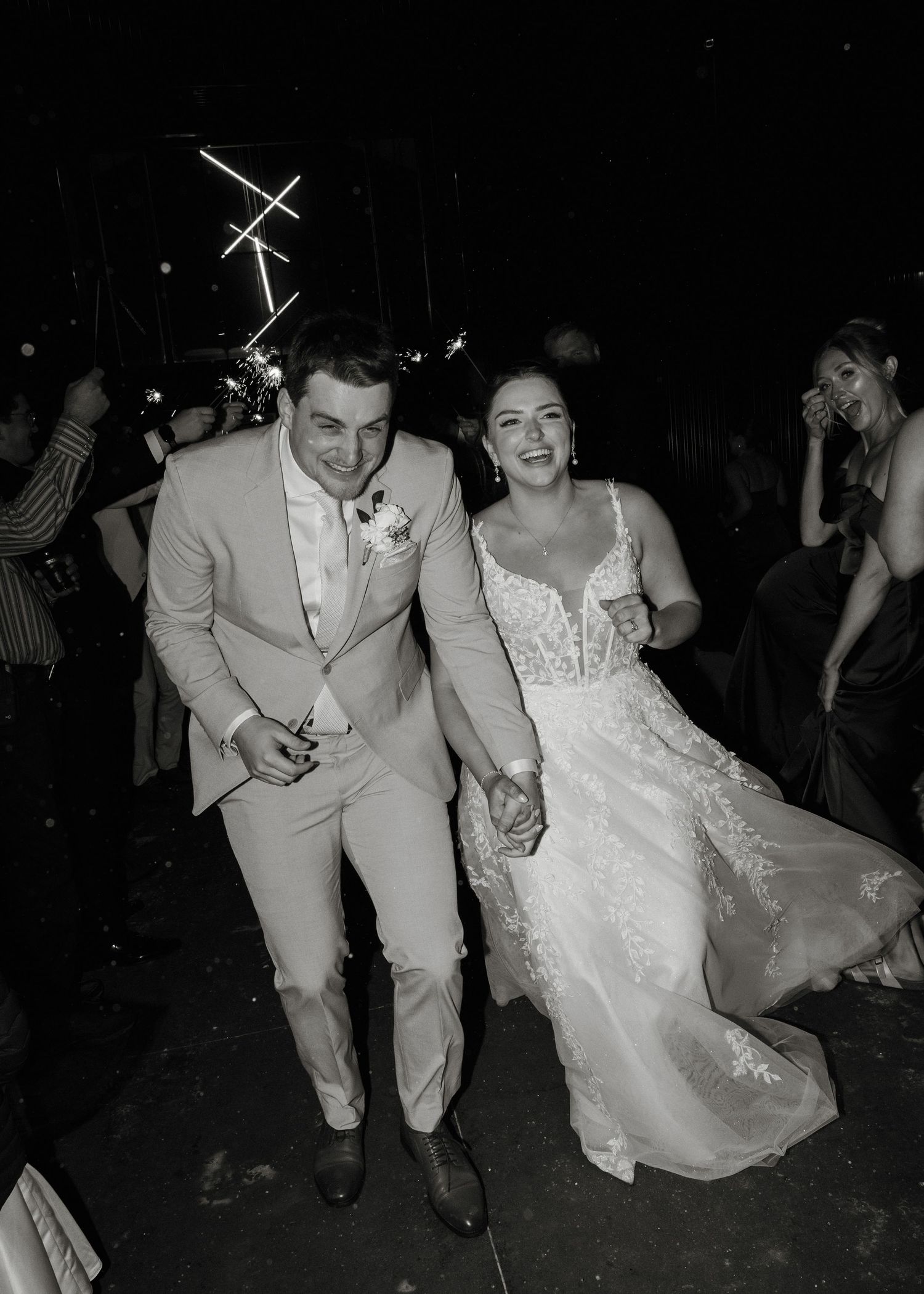 Black and white photos of a wedding couple dancing and celebrating at their reception in formal attire.