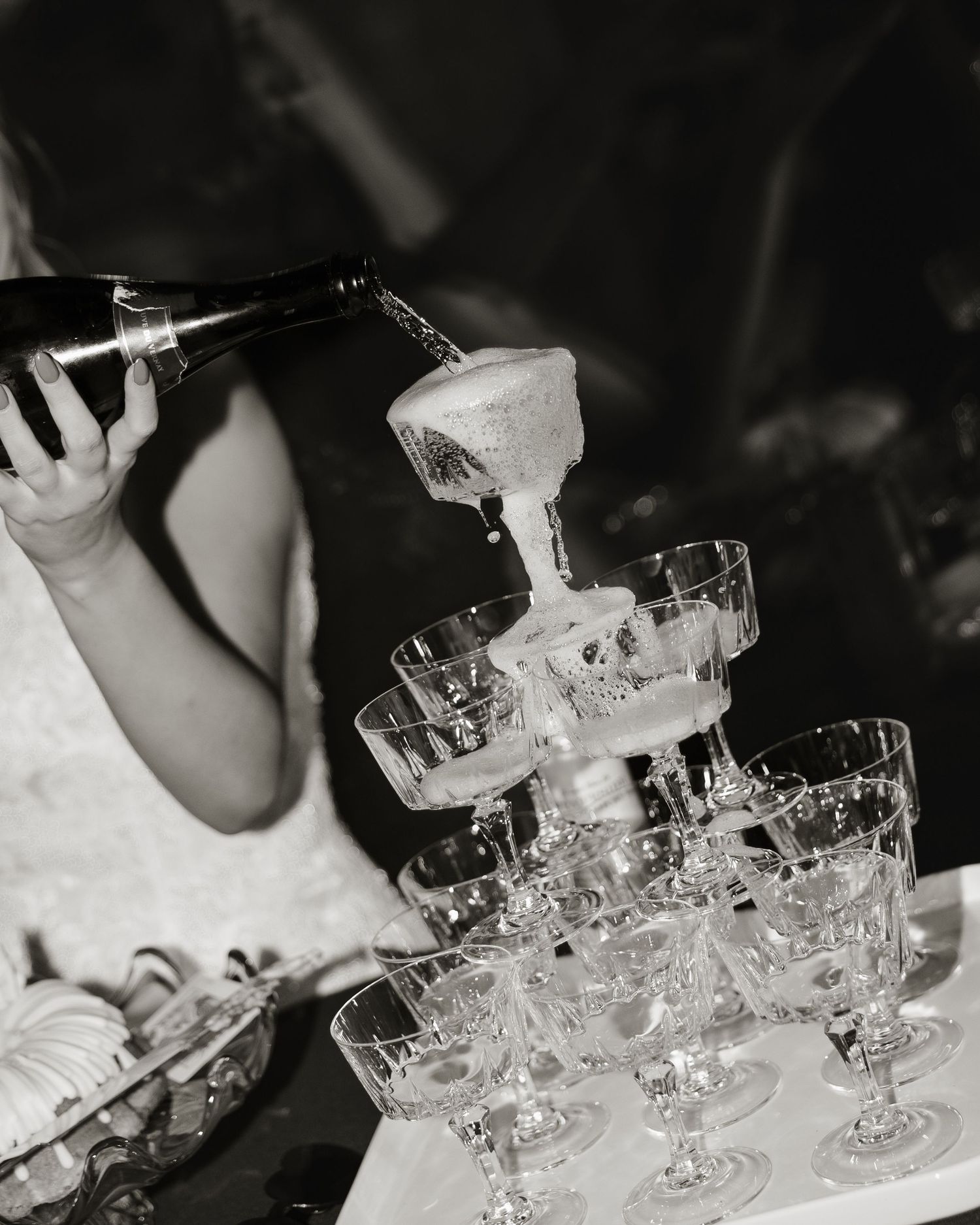 A series of champagne glasses arranged in rows on a dark surface, creating an elegant display for a celebration.